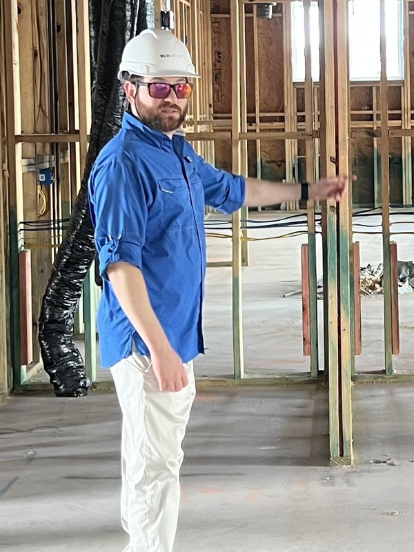 Greg Baumann, founder of Flikt.AI and licensed general contractor, on a wood-framed jobsite at rough-in